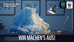 Earth Hour 2026 Symbolisch liegt ein schmelzender Eisblock mit einem Eisbären auf dem Schreibtisch. Hinweis auf die Earth Hour am 28. März 2026