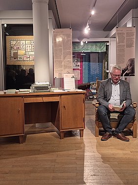 Bürgermeister Stefan Pöhlmann liest die Geschichte "Die Raala" Der Bürgermeister sitzt auf dem original Sessel von Otto Knopf und liest zur Vernissage der Sonderausstellung seiner Ehren die Geschichte die Raala