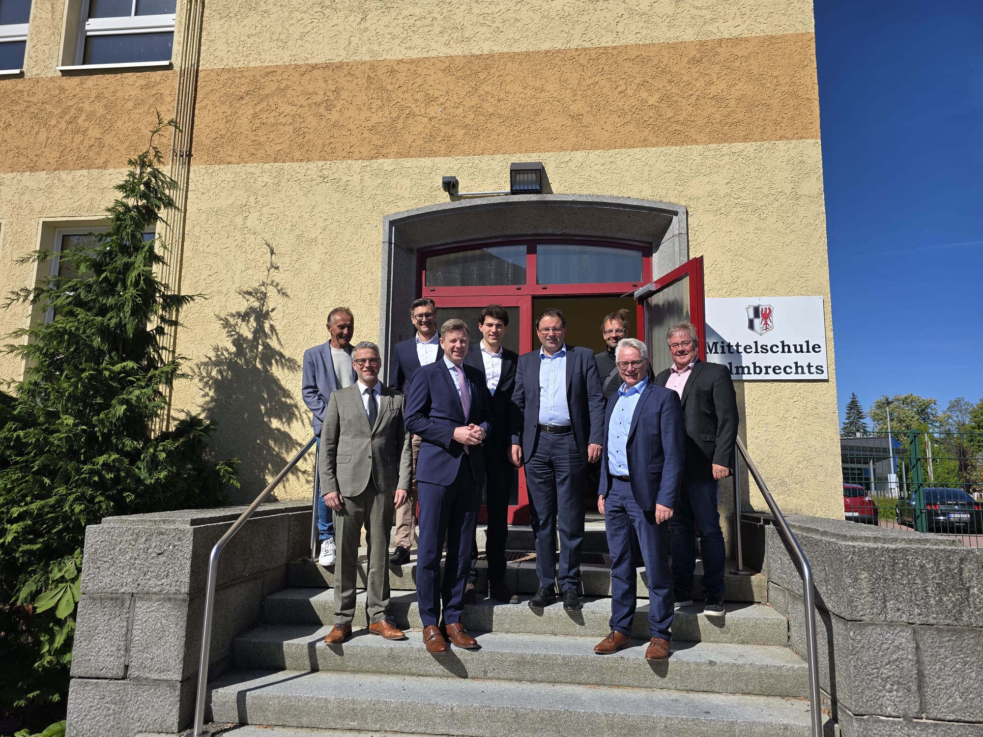 Die neuen Herren auf den Treppen der Mittelschule Helmbrechts, die zum gemeinsamen Pausenhof mit der Grundschule führen. Im Hintergrund ist die zu sanierende Mittelschule zu sehen.