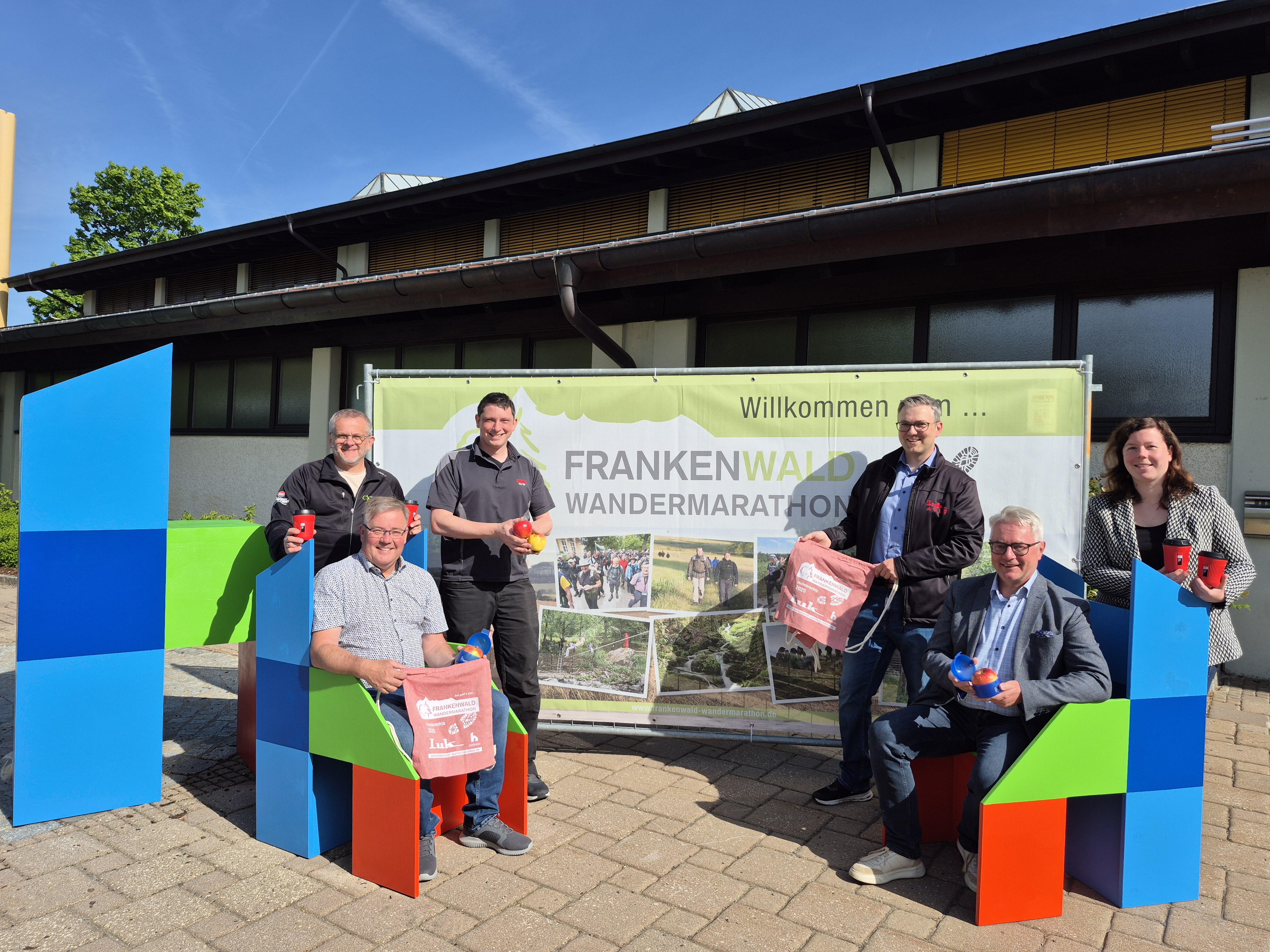 Bei Sonne und blauem Himmel stehen drei Vertreter Helmbrechtser Firmen gemeinsam mit Geschäftsführer des Frankenwald Tourismus, Stadtbauamtsleiter und Bürgermeister der Stadt Helmbrechts vor der Göbel-Halle als Start- und Zielort.