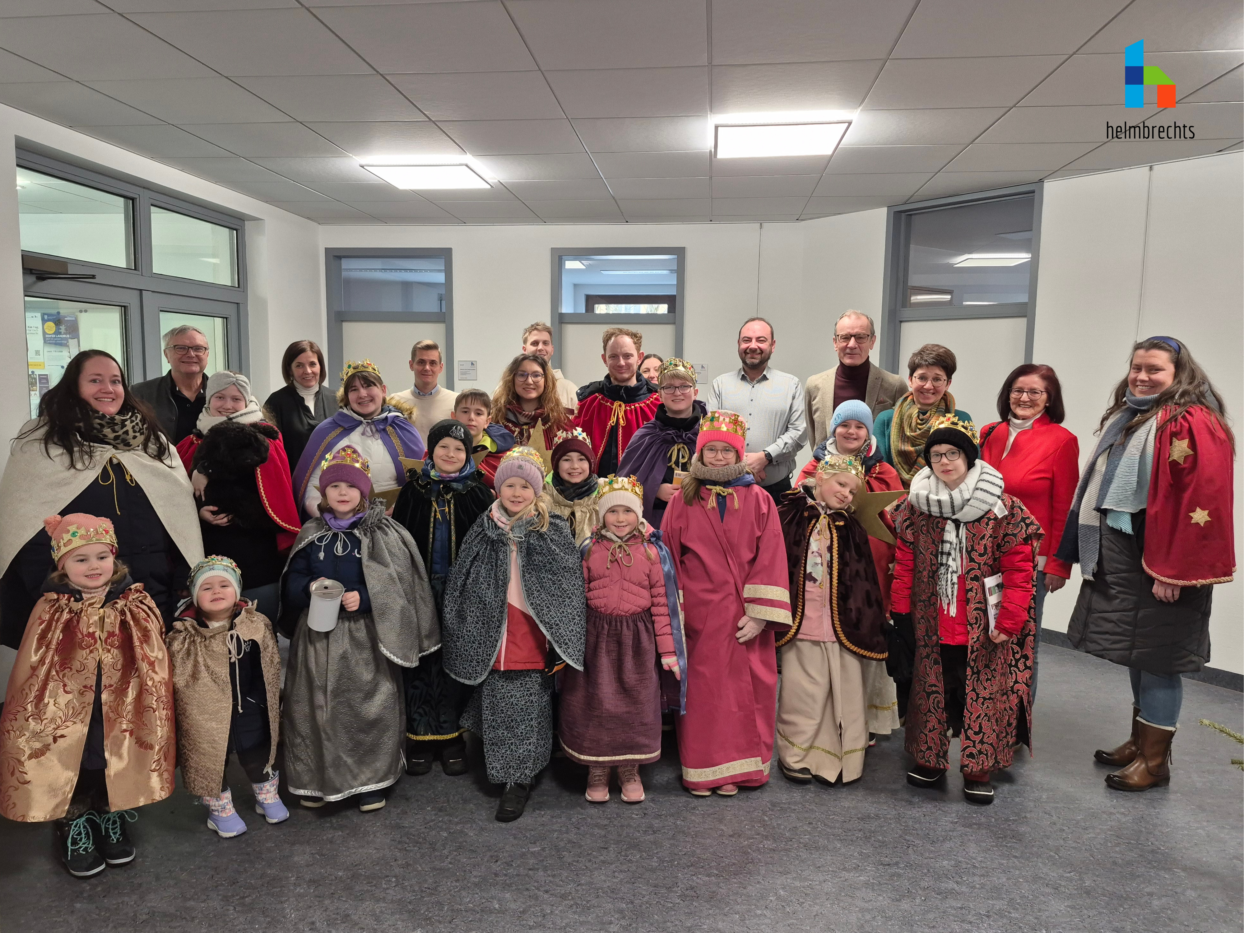Kinder verkleidet in Gewändern der Heiligen Drei Könige, stellvertretende Bürgermeister und Mitarbeiter der Stadtverwaltung gemeinsam im Rathaus