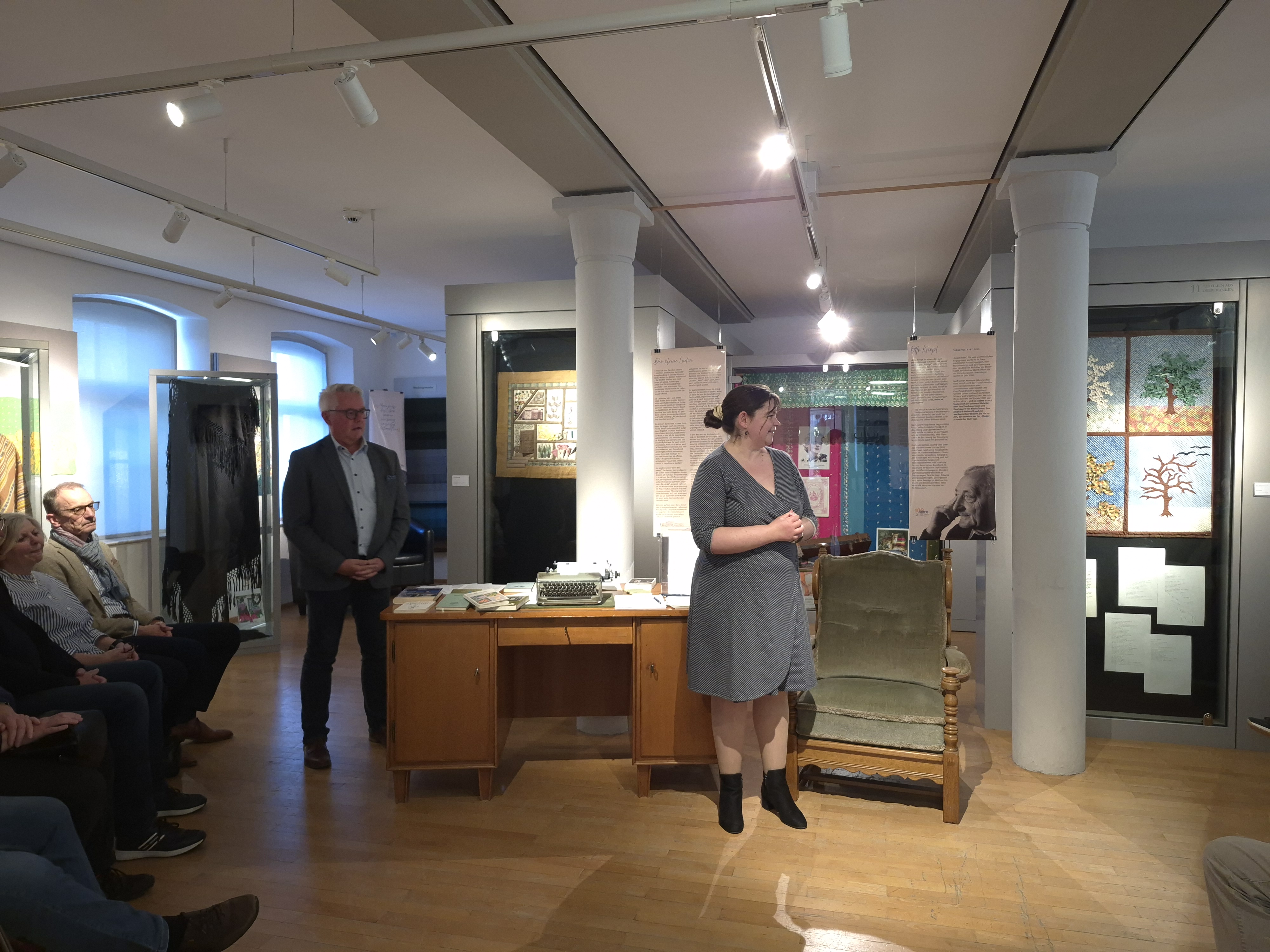 Eröffnung Vernissage Sonderausstellung Otto Knopf Lena Grießhammer steht vor dem original Schreibtisch von Otto Knopf. Links dahinter steht Bürgermeister Stefan Pöhlmann. Sie eröffnen die Vernissage zur Sonderausstellung Otto Knopf.