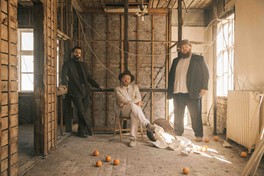 LÓN Die dreiköpfige Band steht auf einer Baustelle und sieht direkt in die Kamera