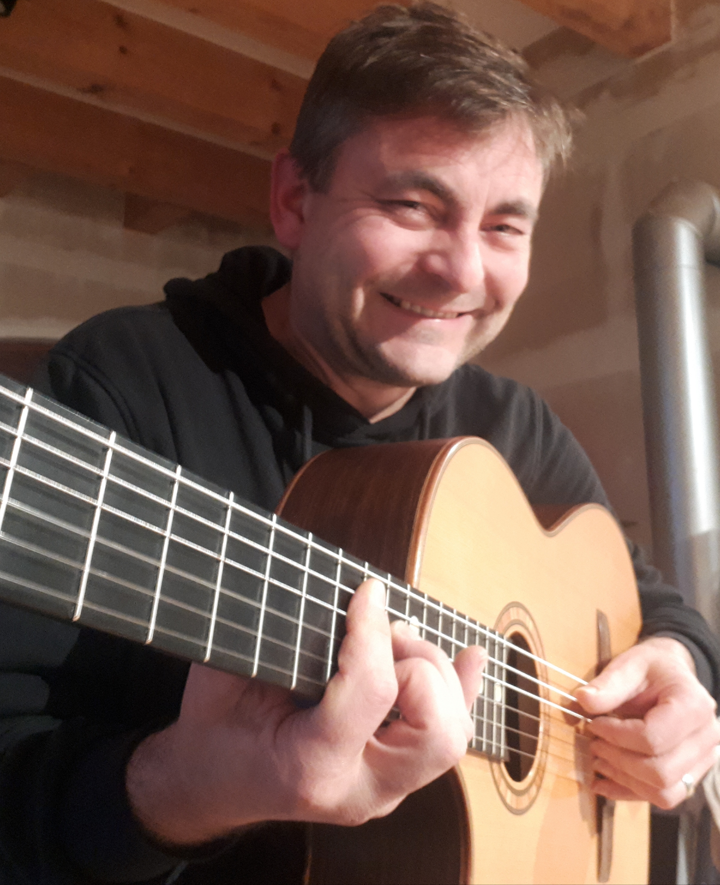 Der lachende Gitarrist Ralf Wunschelmeier mit seiner Gitarre