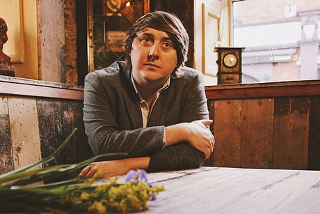 Singer-Songwriter John Blek beim Shooting auf einer Holzeckbank